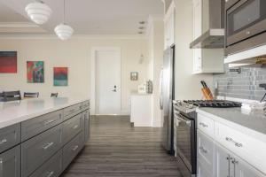 a kitchen with white cabinets and a stove top oven at Seagate House -Waterfront w Dock in Key West