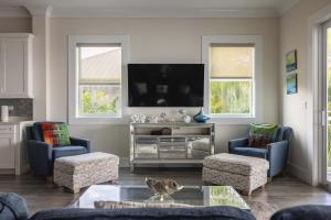 a living room with two chairs and a flat screen tv at Seagate House -Waterfront w Dock in Key West
