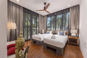 two beds in a room with large windows at VILLA PULAU 3 bedroom Baan Bua Estate in Nai Harn Beach +82 photos