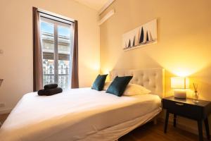 a bedroom with a large white bed with a window at Chambre 2 La Calada in Nice