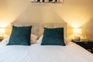 a bedroom with a white bed with two blue pillows at Chambre 2 La Calada in Nice
