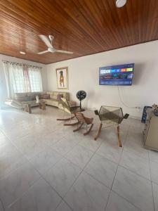a living room with chairs and a tv on the wall at Casa con tres dormitorios y garaje in Montería