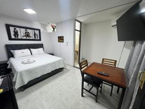 a bedroom with a bed and a wooden table at Apartamentos amoblados de 1, 2 y 3 dormitorios in Nueva Ola