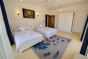 a bedroom with two beds and a rug at Villa Desert Rose in Luxor +21 photos