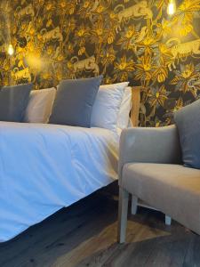a bed and a couch in a room with a wallpaper at The Menagerie in Towcester