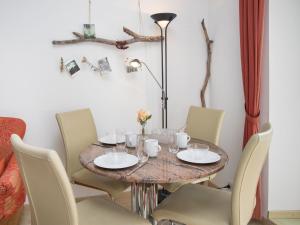 a dining room table with chairs and a round table with glasses at Apartment Alpes et Lac 28 by Interhome in Champex