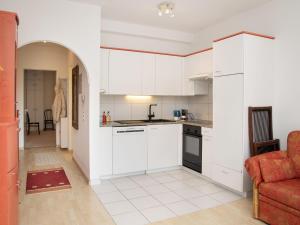 a kitchen with white cabinets and a red couch at Apartment Alpes et Lac 28 by Interhome in Champex +33 photos