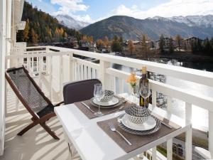 a table on a balcony with a view of the mountains at Apartment Alpes et Lac 28 by Interhome in Champex