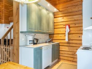 a kitchen with wooden walls and cabinets and a sink at Holiday Home Kranni 1 by Interhome in Syöte