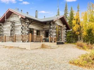 a log cabin with a porch in the woods at Holiday Home Kojamopirtit by Interhome in Kolari