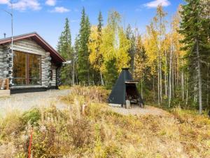 a cabin in the woods with a fireplace in the yard at Holiday Home Kojamopirtit by Interhome in Kolari