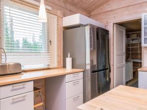 a kitchen with white cabinets and a refrigerator at Holiday Home Isokuru 3 by Interhome in Pyhätunturi +9 photos