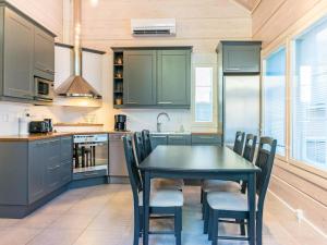 a kitchen with a black table and chairs at Holiday Home Otso by Interhome in Pyhätunturi