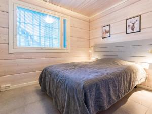 a bedroom with a bed in a wooden room at Holiday Home Otso by Interhome in Pyhätunturi +15 photos