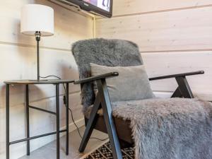 a chair next to a table with a lamp at Holiday Home Otso by Interhome in Pyhätunturi