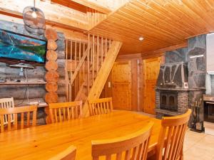 a dining room with a wooden table and a fireplace at Holiday Home Joikupirtti a by Interhome in Pyhätunturi
