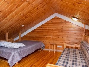 a bedroom with a bed in a wooden attic at Holiday Home Joikupirtti a by Interhome in Pyhätunturi +12 photos