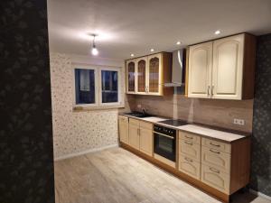 a kitchen with wooden cabinets and a stove top oven at Lewitz-Urlaub in Lübesse