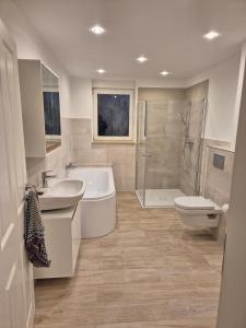 a bathroom with a tub and a sink and a toilet at Lewitz-Urlaub in Lübesse +3 photos