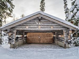 a large wooden garage with snow on top of it at Holiday Home Joikupirtti b by Interhome in Pyhätunturi