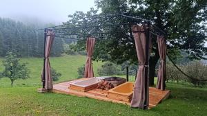 a gazebo with a bath tub in a field at Western Style Planenwagen in Henndorf