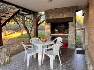 a table and chairs on a patio with a fireplace at La Quinta Resort in Merlo