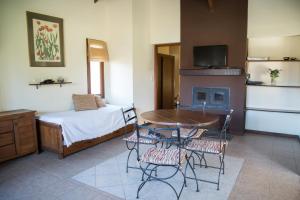 a room with a bed and a table and chairs at La Quinta Resort in Merlo +168 photos