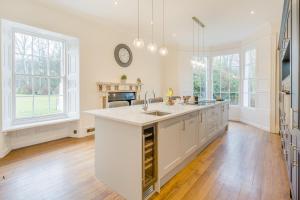 a large kitchen with white cabinets and a fireplace at 4 Bed in Armathwaite oc-e34641 in Armathwaite