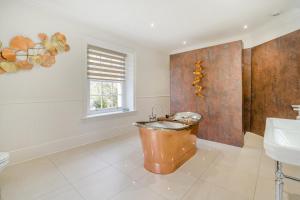 a bathroom with a copper tub and a sink at 4 Bed in Armathwaite oc-e34641 in Armathwaite +22 photos