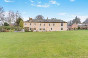 a large grassy field in front of a large house at 4 Bed in Armathwaite oc-e34641 in Armathwaite