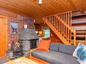 a living room with a couch and a fireplace at Holiday Home Pikku pyhis by Interhome in Pyhätunturi