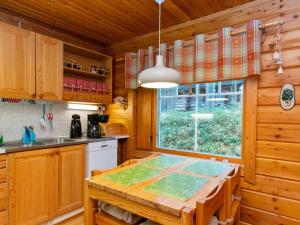 a kitchen with wooden cabinets and a wooden table at Holiday Home Pikku pyhis by Interhome in Pyhätunturi +11 photos