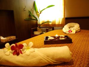 a room with a bed with towels and a tray with a candle at River Resort & Spa in Sa Kaeo
