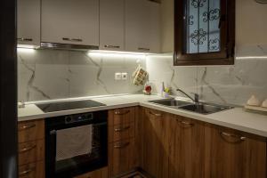 a kitchen with a sink and a stove at ΠΟΛΥΤΕΛΕΣ -ΜΟΝΤΕΡΝΟ ΔΙΑΜΕΡΙΣΜΑ in Larisa +26 photos