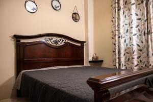 a bedroom with a bed and three clocks on the wall at ΠΟΛΥΤΕΛΕΣ -ΜΟΝΤΕΡΝΟ ΔΙΑΜΕΡΙΣΜΑ in Larisa
