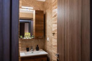 a bathroom with a sink and a mirror at ΠΟΛΥΤΕΛΕΣ -ΜΟΝΤΕΡΝΟ ΔΙΑΜΕΡΙΣΜΑ in Larisa