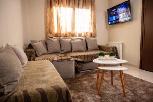 a living room with a couch and a table at ΠΟΛΥΤΕΛΕΣ -ΜΟΝΤΕΡΝΟ ΔΙΑΜΕΡΙΣΜΑ in Larisa