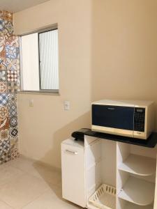 a microwave sitting on top of a counter in a kitchen at Casa três quartos em condomínio in Garanhuns