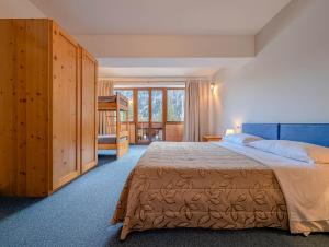 a bedroom with a bed and a large window at Leres Pastry Hotel in Sottoguda