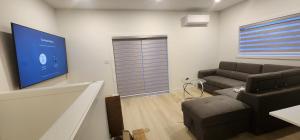 a living room with a couch and a tv at ChessKings Apartments in Winnipeg