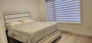 a bedroom with a bed and a large window at ChessKings Apartments in Winnipeg