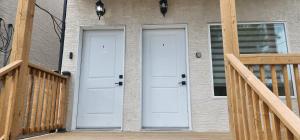 two white doors on a house with a porch at ChessKings Apartments in Winnipeg +2 photos