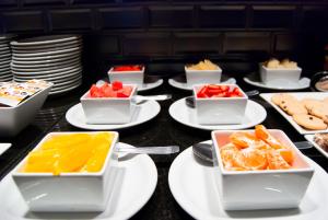 a table topped with white plates and bowls of fruit at THE HOTEL in Córdoba