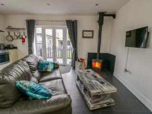 a living room with a couch and a wood stove at Hafod Wen in Pentraeth