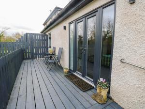 a wooden deck with a table and chairs on a house at Hafod Wen in Pentraeth