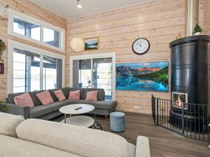 a living room with a couch and a clock on the wall at Holiday Home Metsäpirtti by Interhome in Keuruu