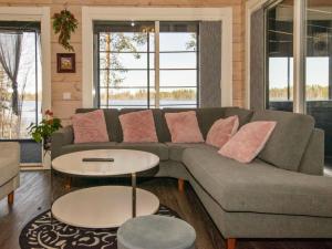 a living room with a couch and two tables at Holiday Home Metsäpirtti by Interhome in Keuruu