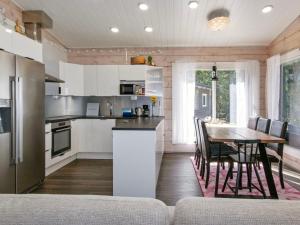 a kitchen with a table and a dining room at Holiday Home Metsäpirtti by Interhome in Keuruu