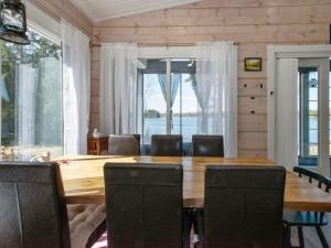 a dining room with a large wooden table and chairs at Holiday Home Metsäpirtti by Interhome in Keuruu +25 photos
