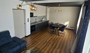 a living room and kitchen with a table and chairs at ZIBO APARTMENTS LESKO Nowoczesne apartamenty z jacuzzi i widokiem na Bieszczady in Lesko
